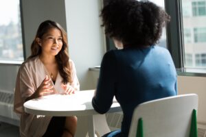 Two women at a table having a conversation about returning to the workforce